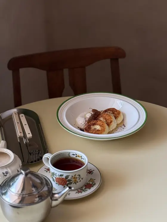 Сырники и чайник с чаем на столе